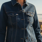 Classic Blue Jean Denim trucker jacket, embroidered logo sleeve, styled on a person at the beach, front view.