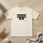 Freebrd Logo Classic T-Shirt in cream, that has a black Freebrd Logo on the chest lying on a tan marble flat surface with a sand stone and dried flowers.