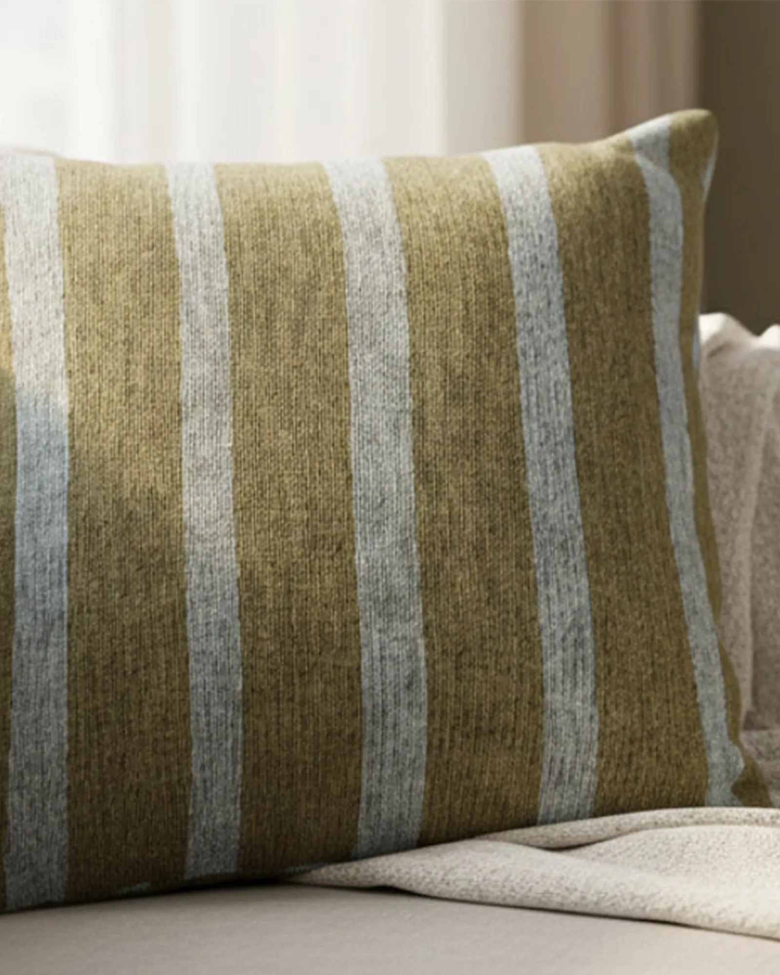 A preview of the Danish Blue Dark Neutral Wood Striped Woven Pillow showing a dark neutral wood background and danish blue pinstripes on a beige couch.