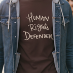 Dark Chocolate Human Rights Defender long sleeve tee styled with denim jacket, cream graphic, street lifestyle front view.