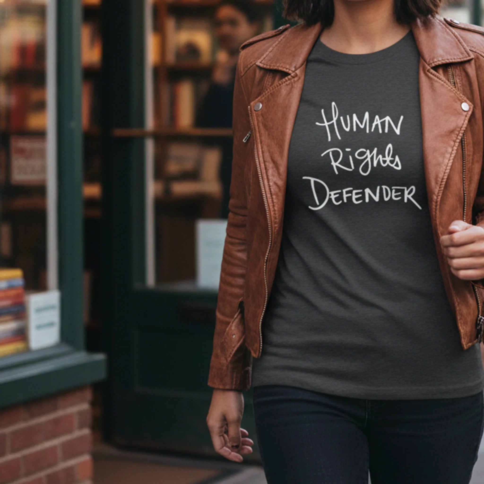 Dark Heather Human Rights Defender long sleeve tee styled with leather jacket, white graphic, street lifestyle front view.