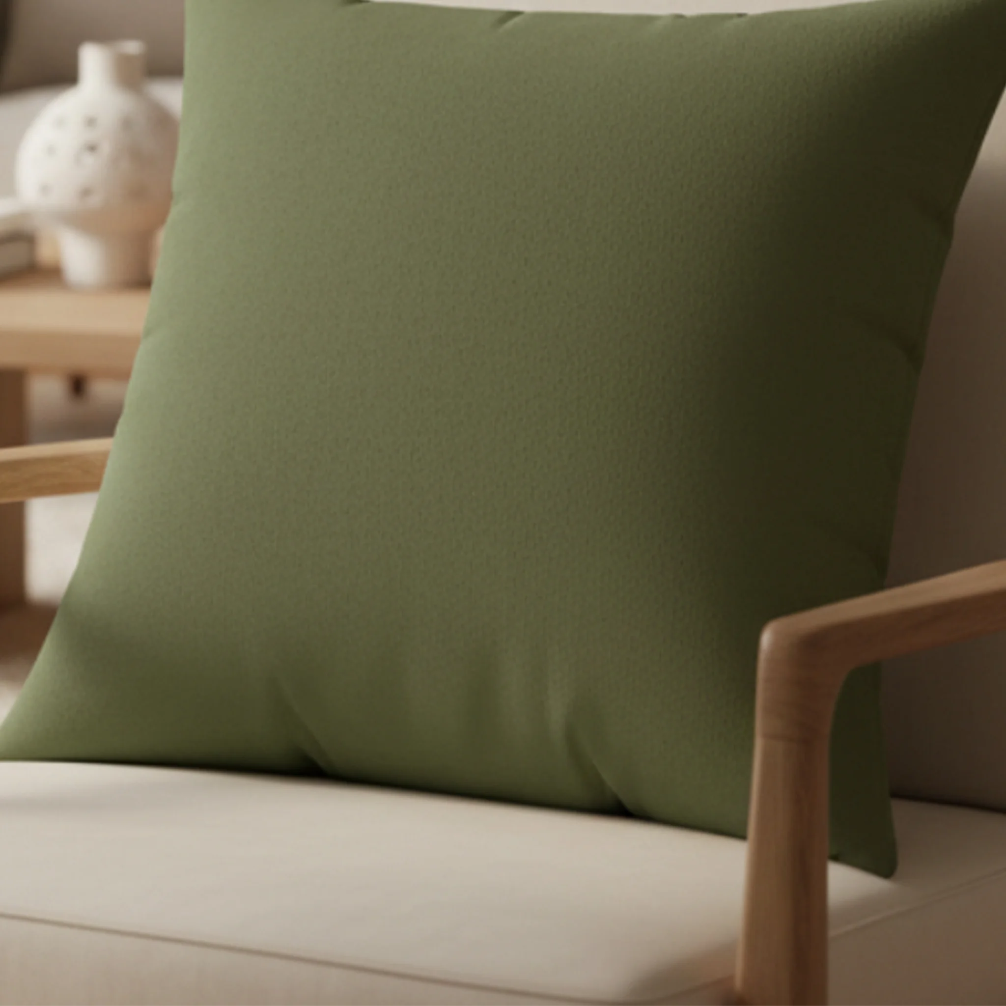 Dark sage faux suede pillow styled on sofa, muted green botanical home decor.