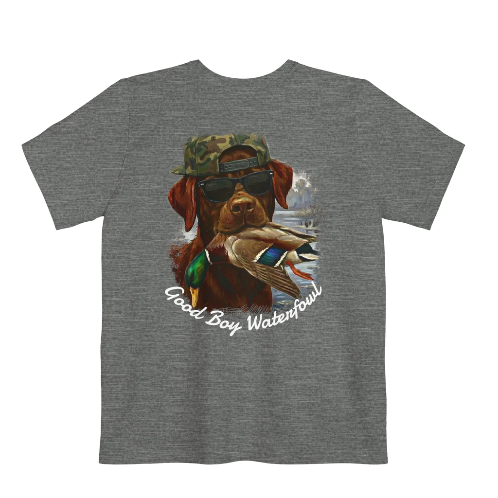 A deep heather t-shirt featuring the Good Boy Waterfowl graphic of a chocolate Labrador wearing sunglasses and a camo snapback, holding a mallard duck, with a watercolor outdoor scene and 'Good Boy Waterfowl' script below.