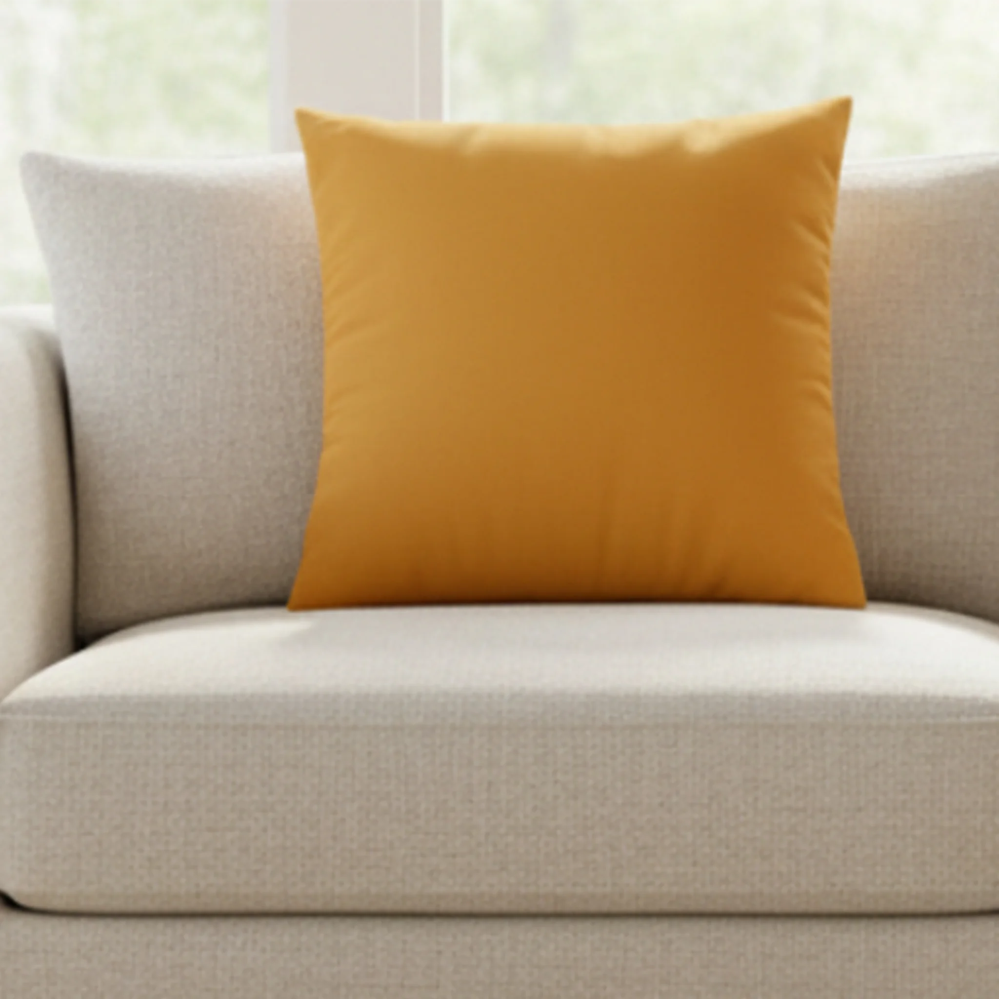 Dixie Orange faux suede pillow case styled on a couch in a modern sunroom. 
