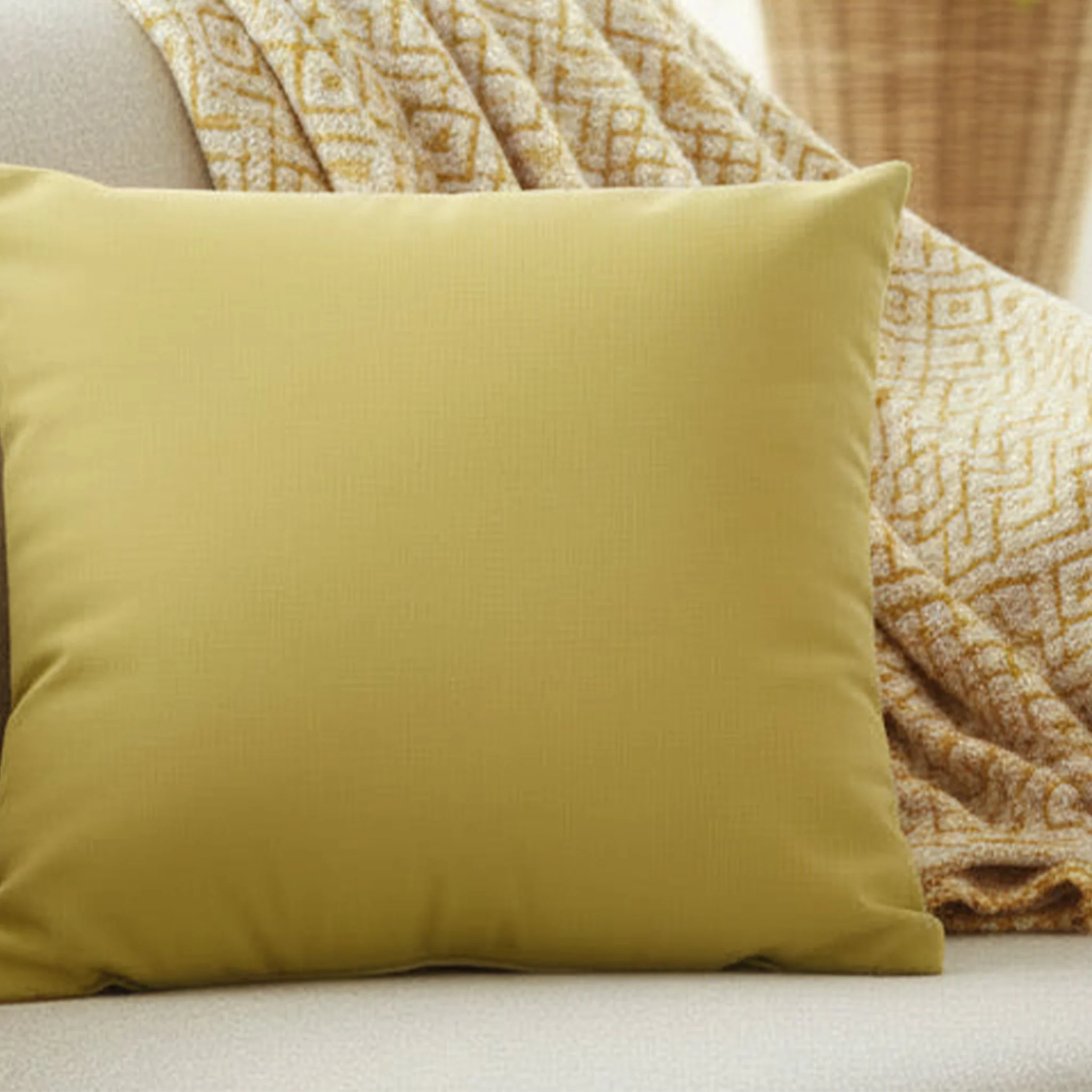 Dull gold yellow faux suede pillow case styled on a couch in a modern living room.