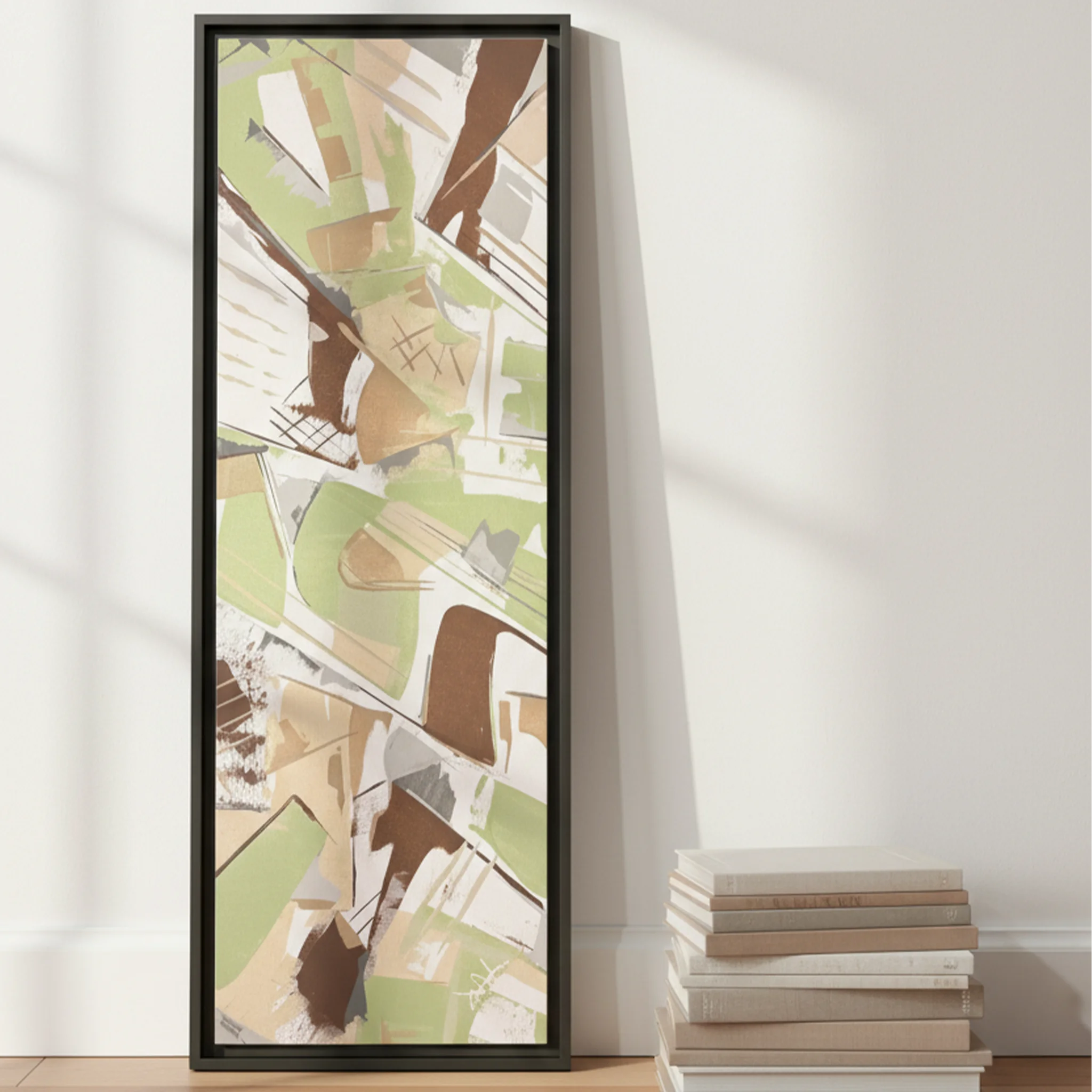 Espresso framed sage abstract canvas 12x36 leaning against wall on floor beside stacked coffee table books, scale reference.