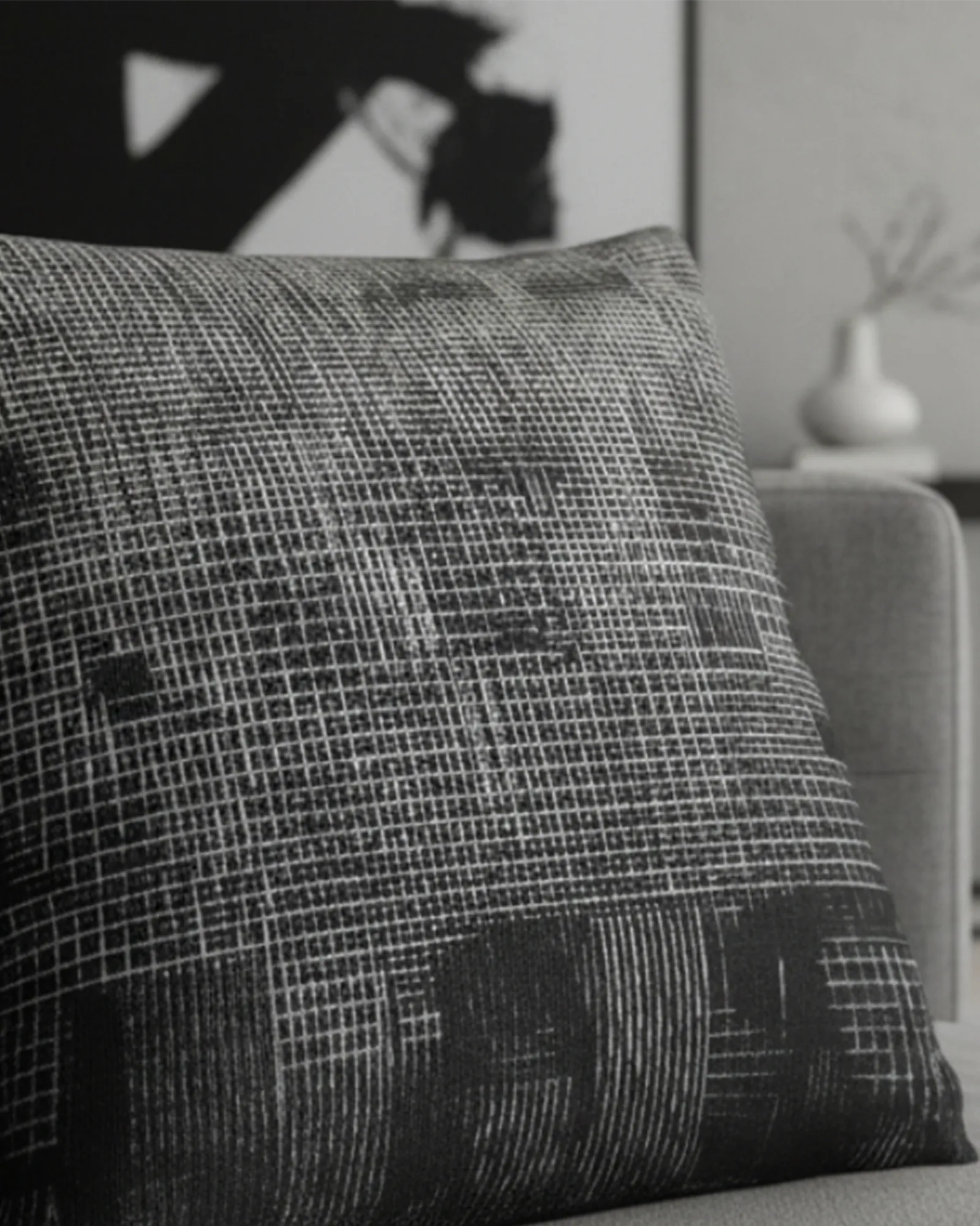 A preview of the Faded Geometric Net Patterned Woven Pillow showing a black background and abstract black and white hash grid lines lying on a grey sofa.