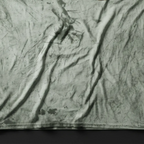 A close-up bird's eye flat lay of the fern cheetah marble tie-dye tee on a dark slate surface, highlighting the garment-dyed wash texture.