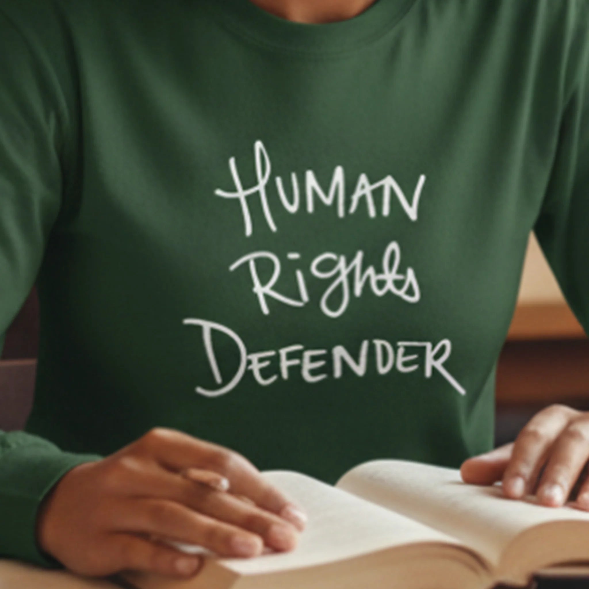 Forest Green Human Rights Defender long sleeve tee, white graphic, lifestyle front view.