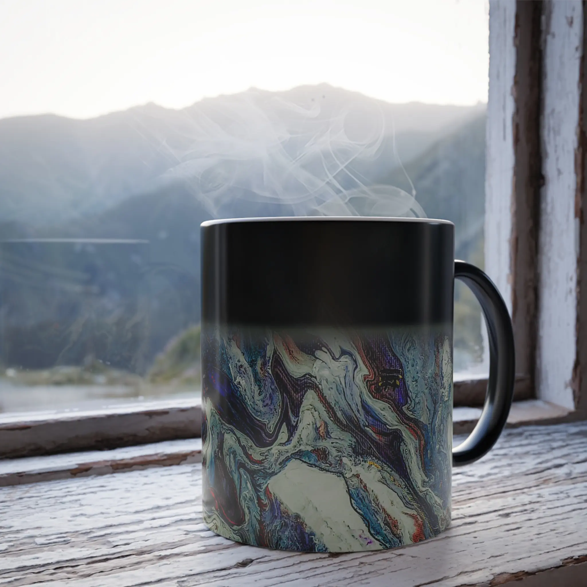 Freebrd Afrostar color changing mug lifestyle shot showing heat reactive abstract acrylic pour artwork revealed by hot liquid on 11oz ceramic mug.