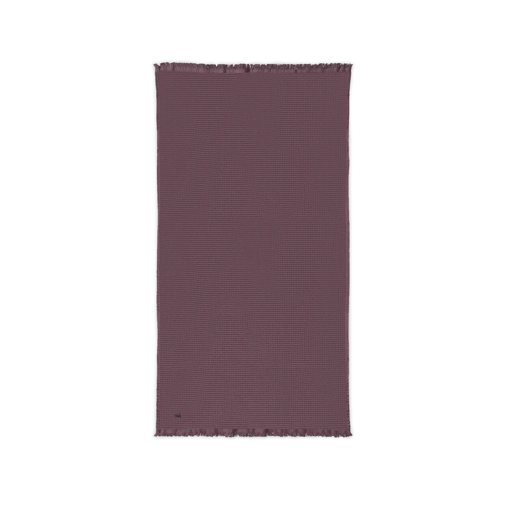 Dusky Orchid cotton waffle throw blanket laid flat, showing its textured surface and fringed ends.
