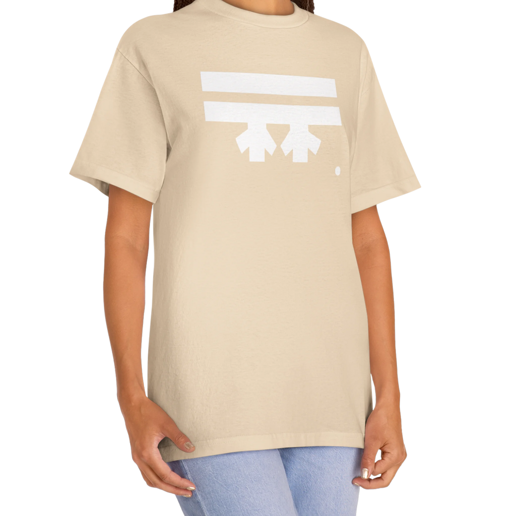 A woman wearing a sand FREEBRD Logo Classic T-Shirt, close-up showing the white FREEBRD logo on the chest.