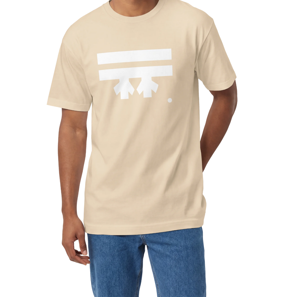 A man wearing a sand FREEBRD Logo Classic T-Shirt, close-up showing the white FREEBRD logo on the chest.