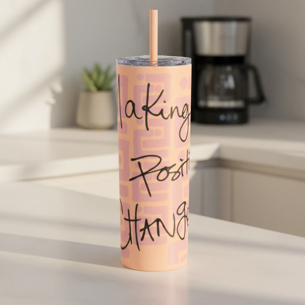 Freebrd Making Positive Changes peach blush skinny tumbler with black script text on a clean modern kitchen counter in soft natural morning light.