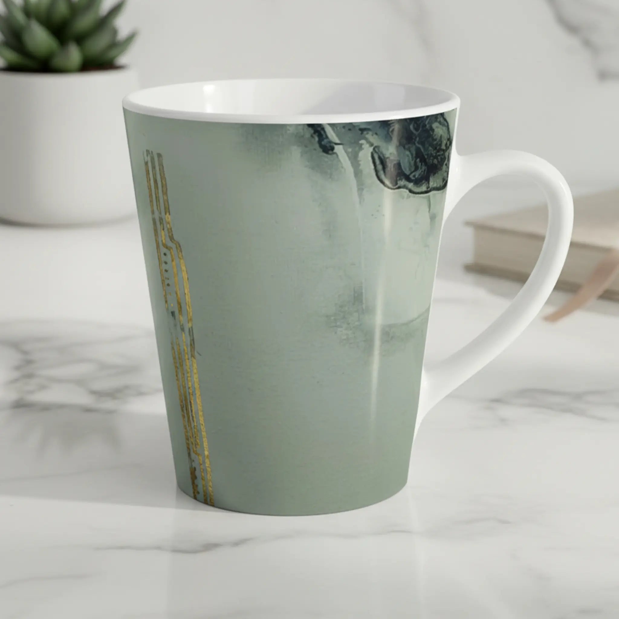 Freebrd Tu Gough abstract marble latte mug with black and gold accents sitting on a clean modern kitchen counter in soft natural morning light.