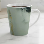 Freebrd Tu Gough abstract marble latte mug with black and gold accents on a modern kitchen counter bathed in soft diffused morning light.