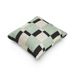 A side view of the Fresh Green Carbon Floater Checker Woven Pillow showing fresh green checker squares floating above carbon fiber black checker squares on an oatmeal cream background. 