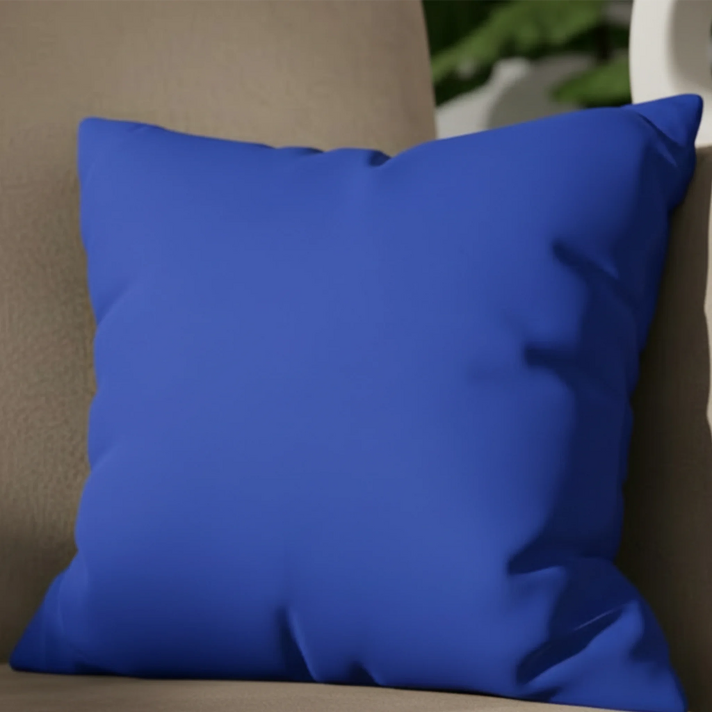 Funky blue faux suede pillow case styled on a modern couch in a living room.