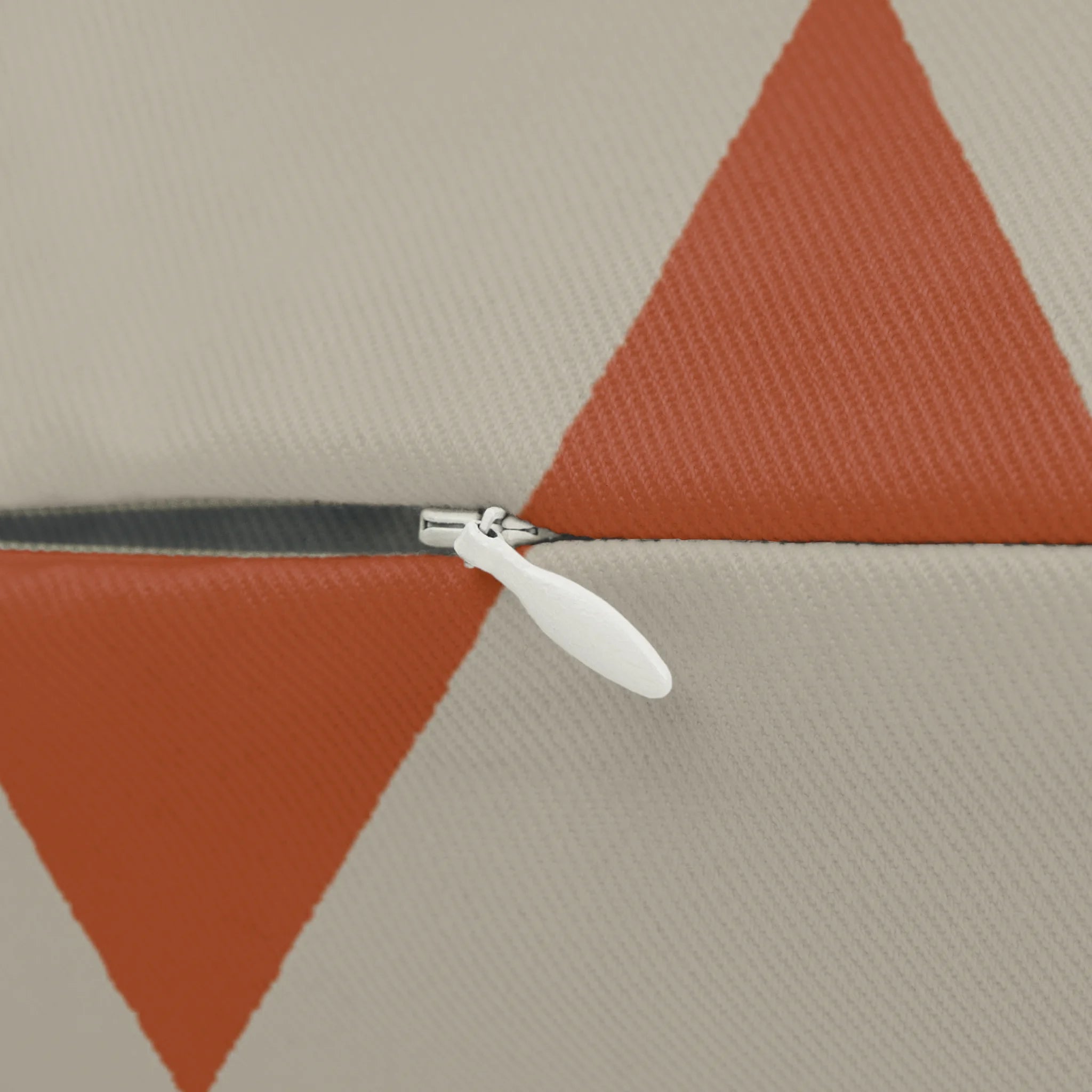 Geometric terracotta triangle lumbar pillow, zipper view.