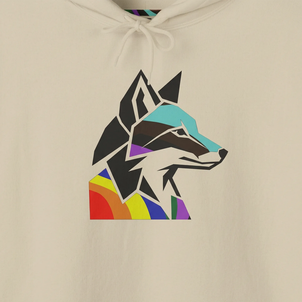 Close-up of a geometric wolf head graphic on a sand-colored hoodie, showing angular black shapes with turquoise, purple and rainbow-colored accents.