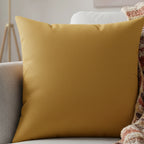 Gold ochre faux suede pillow styled on sofa, warm mustard earthy home decor.
