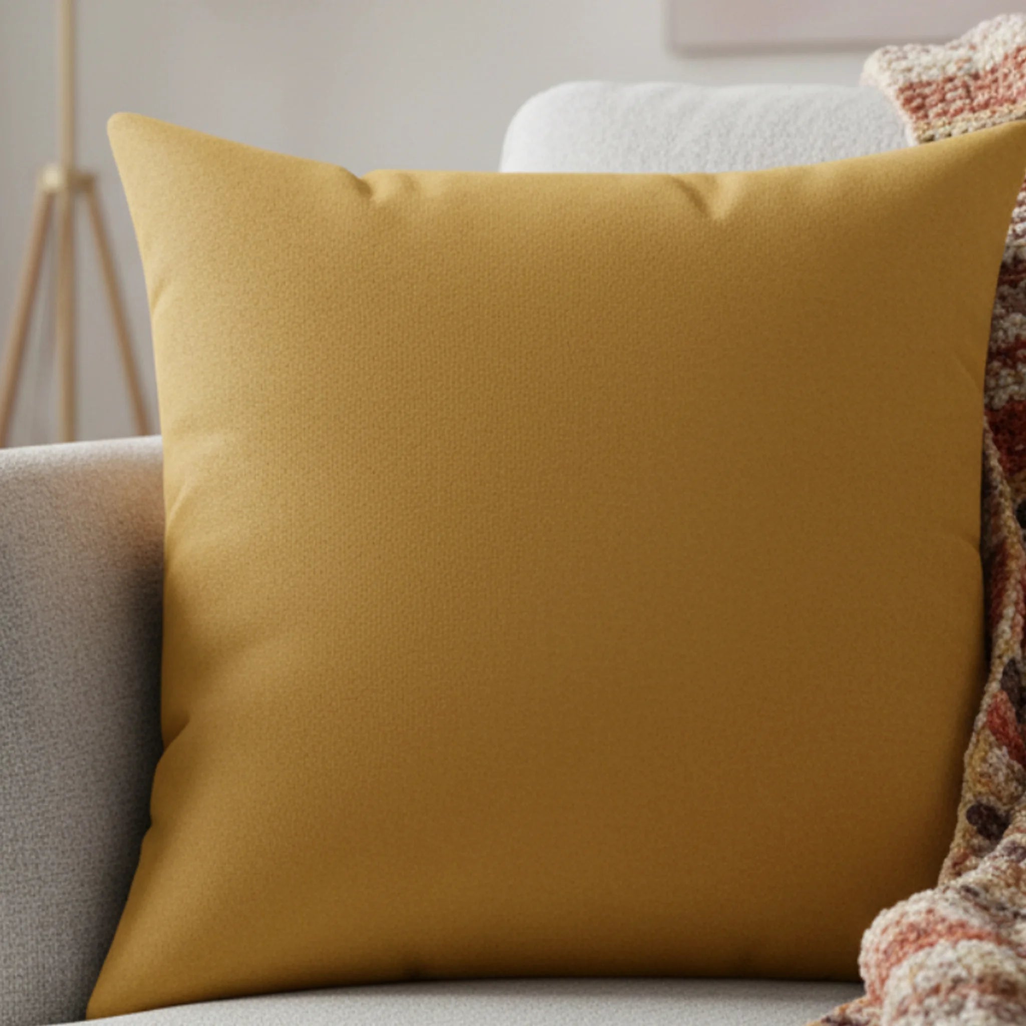 Gold ochre faux suede pillow styled on sofa, warm mustard earthy home decor.