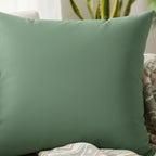 Green dust faux suede pillow, styled on a couch lifestyle view. 