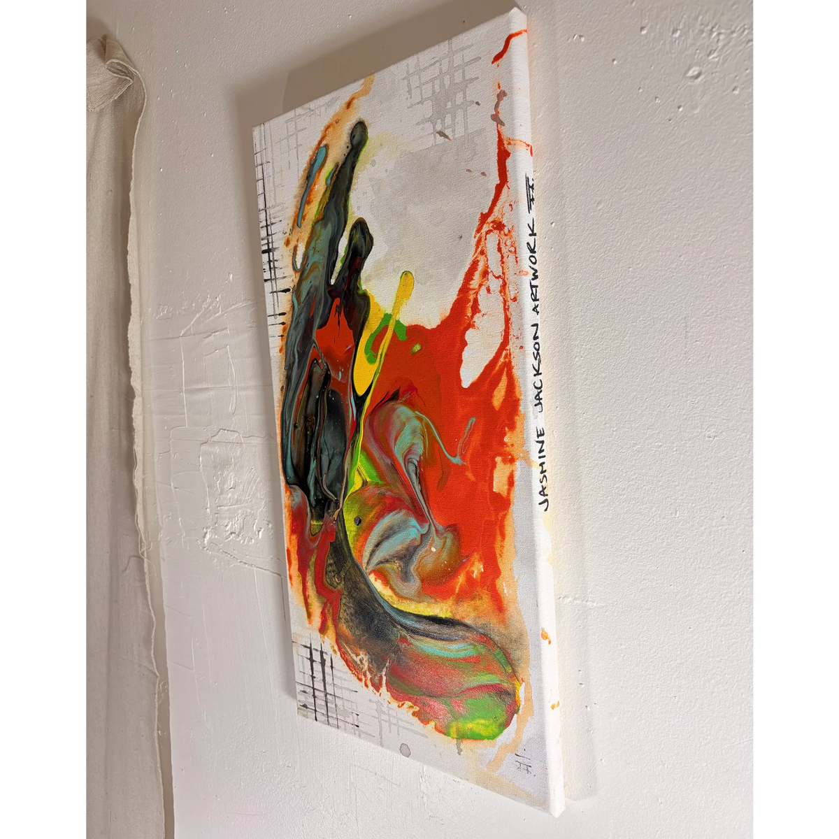 Grid Riser Rhino abstract painting viewed from the right, showing the canvas depth, colorful poured paint, grid details, and artist handwritten Jasmine Jackson Artwork lettering on the edge.
