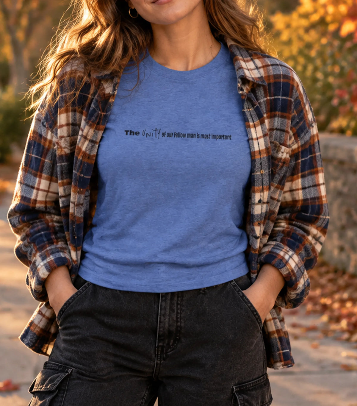 Vintage Royal crew tee worn layered under an open plaid flannel with black denim cargo pants, outdoor fall setting, chest text visible.