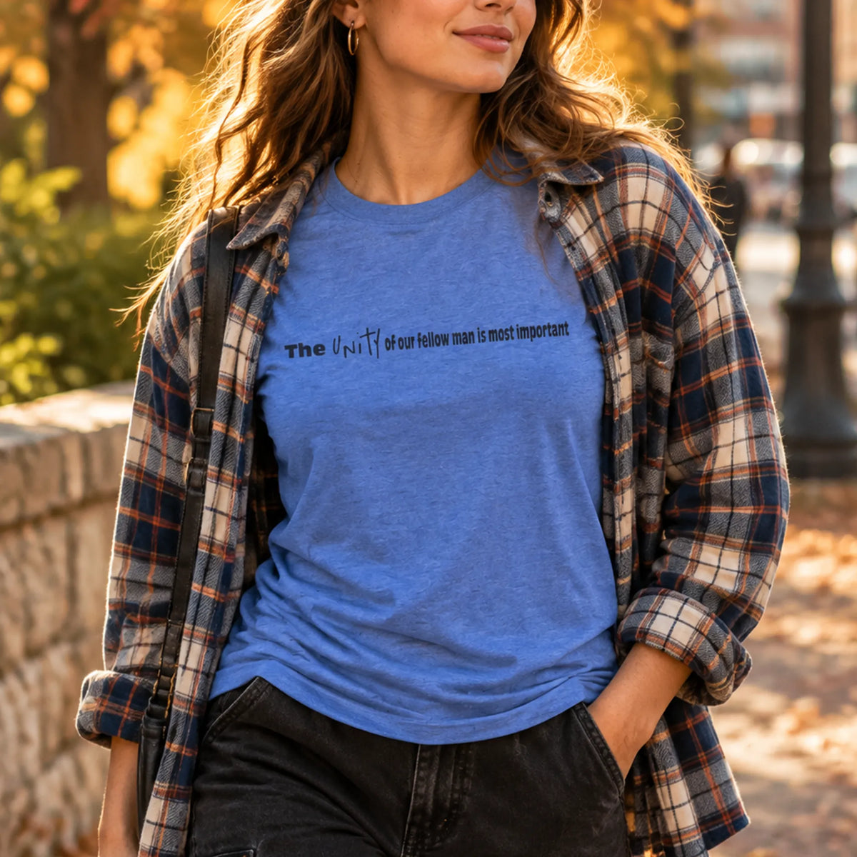 Vintage Royal crew tee worn layered under an open plaid flannel with black denim cargo pants, outdoor fall setting, chest text visible.