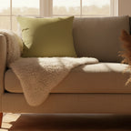 Khaki olive faux suede throw pillow styled in a modern Scandinavian living room.