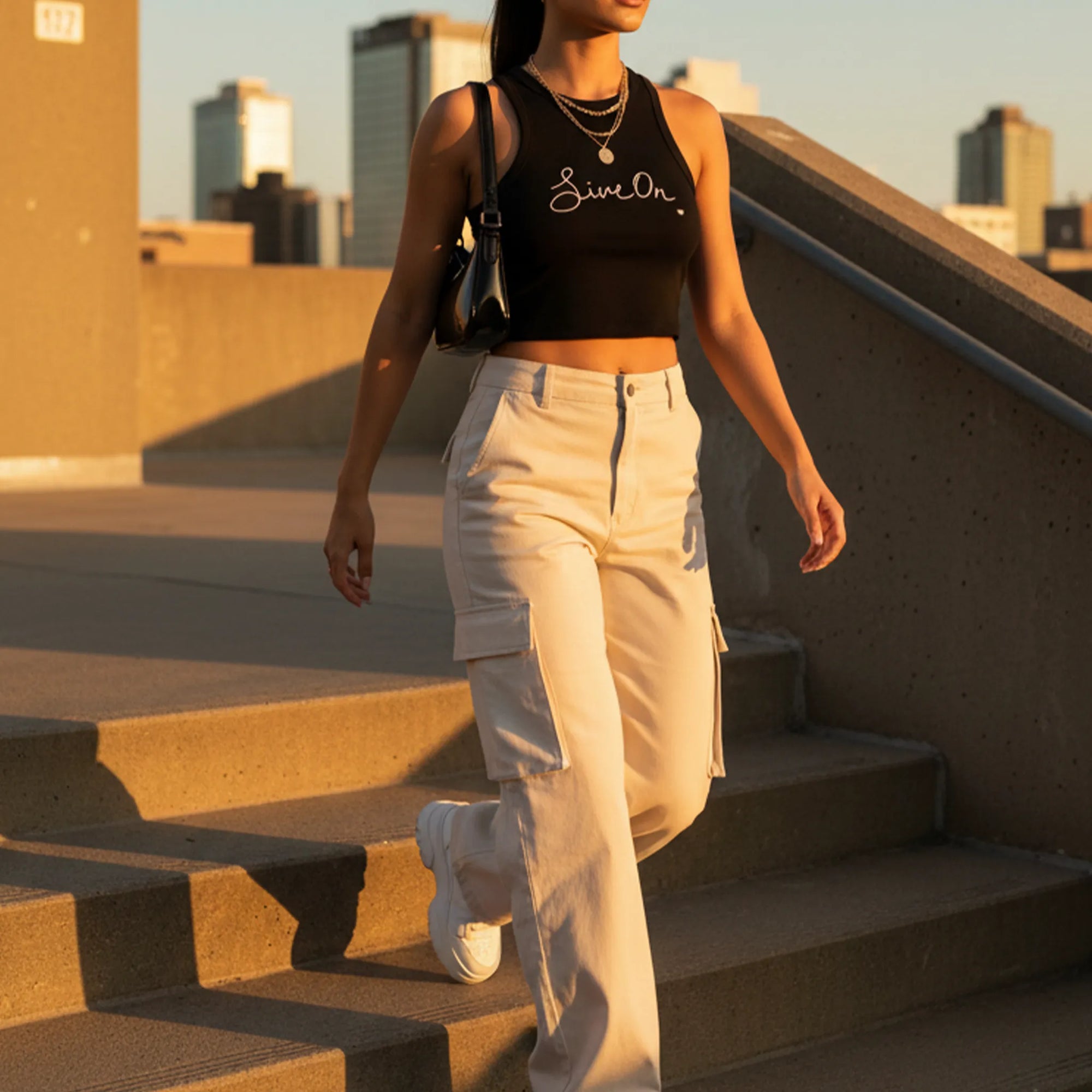 Live On. black cropped racer tank, styled outfit, golden hour rooftop, lifestyle editorial.