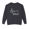 Black crewneck pullover with light-colored Love is Peace lettering across the chest, front view.