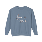 Muted blue crewneck pullover with white Love is Peace lettering and a dark offset shadow, front view.