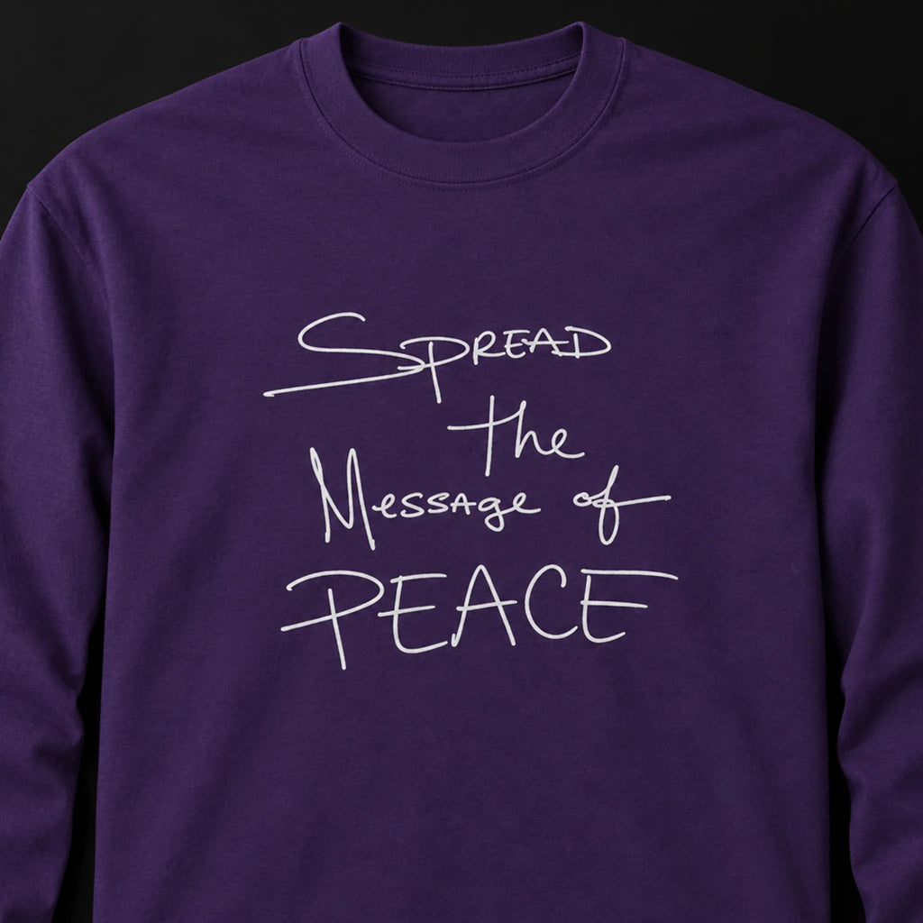 Close-up of a purple long-sleeve tee with white handwritten lettering reading Spread the Message of Peace.