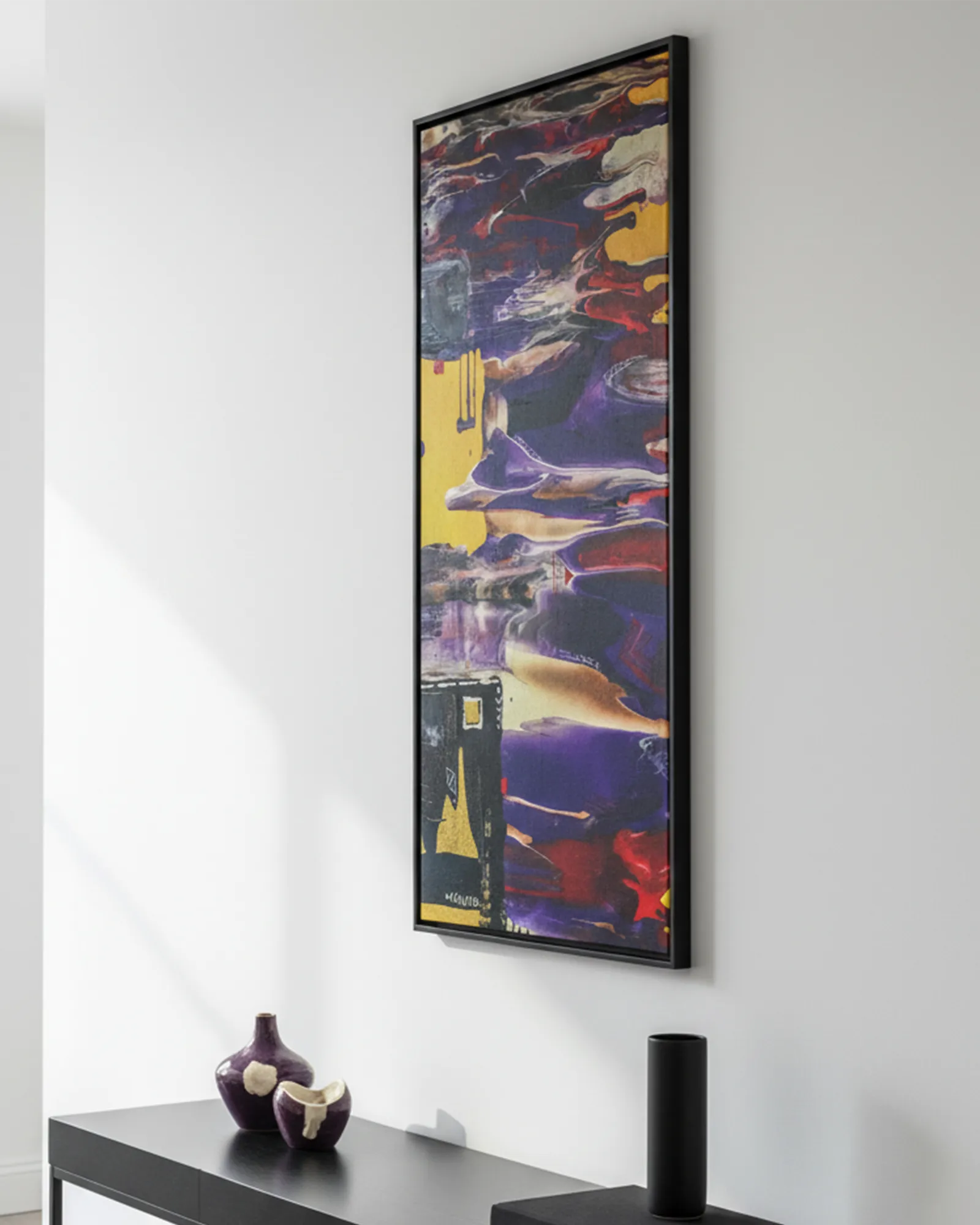 Abstract ‘Tribal Wave’ black framed canvas with vibrant colors on a white wall above a black console table.
