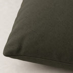 Close-up of the Moss Bronze pillow cover showing its dark gray-olive woven surface and stitched edge.