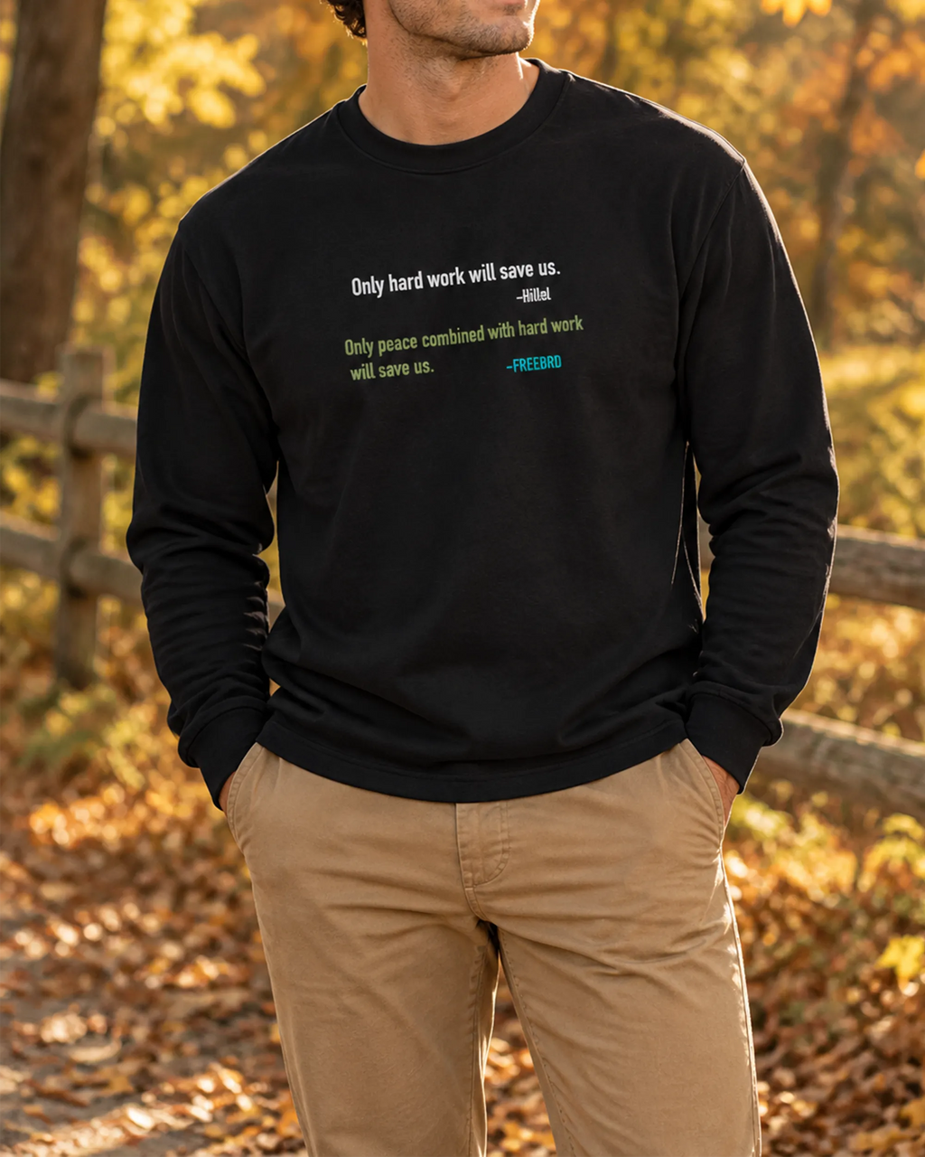 Black long sleeve tee with motivational quote graphic, lifestyle photo of a man in khaki pants outdoors in a fall setting.
