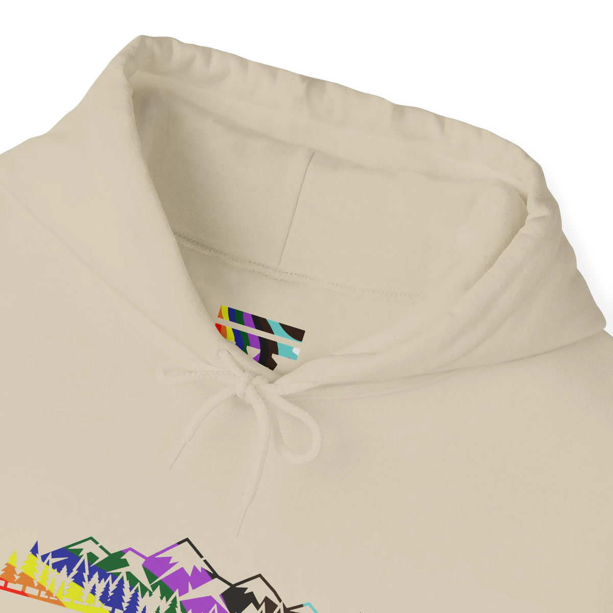 Close-up of a sand-colored hoodie neckline showing a multicolored FREEBRD LGBTQIA Pride inner-neck logo, matching drawstrings and part of the mountain graphic.