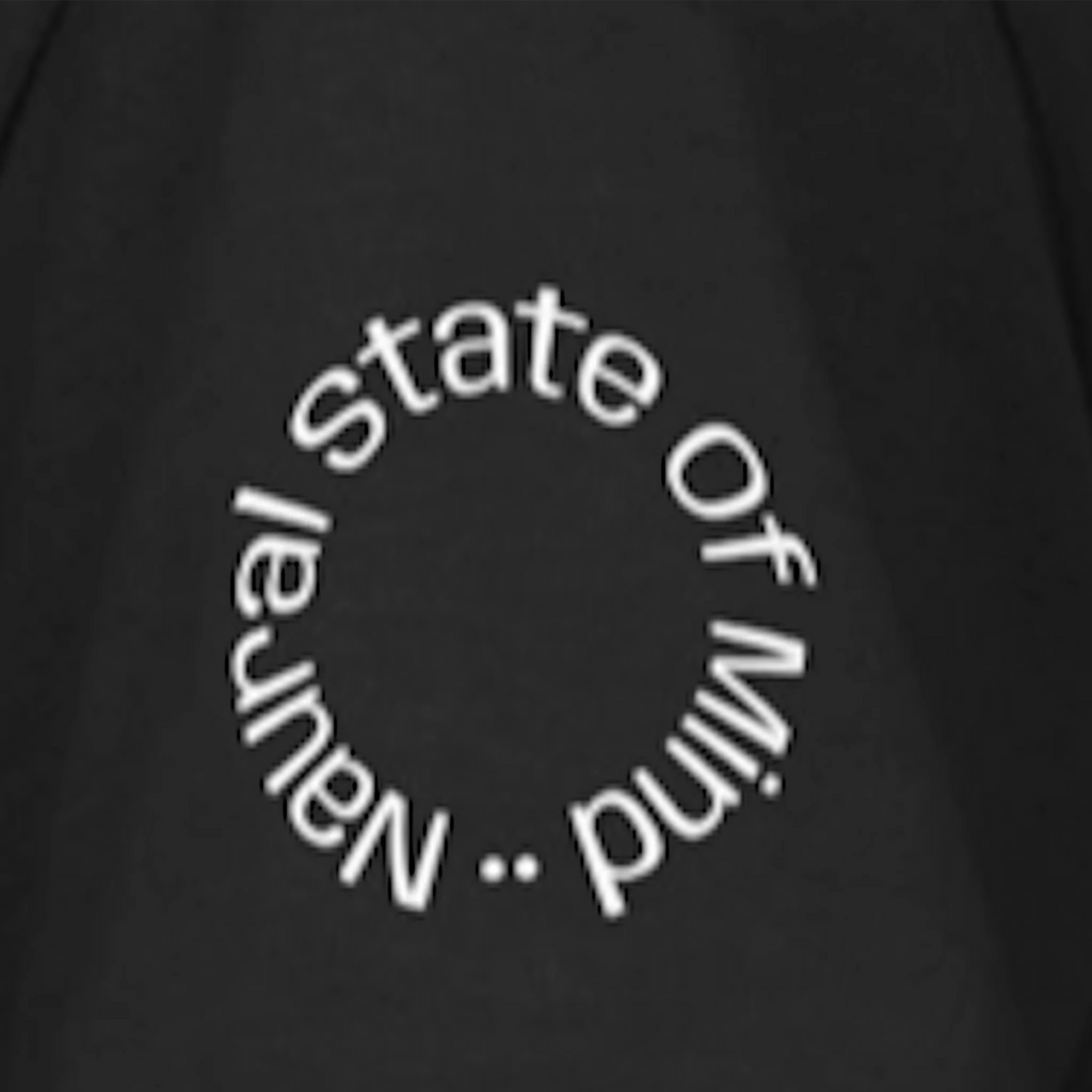 A close-up of the right sleeve of a black FREEBRD Natural State of Mind t-shirt showing 'Natural State of Mind' circular white text