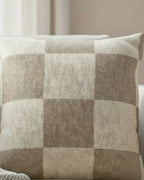 White linen armchair in a soft minimalist living room with sheer curtains and natural window light styled with the Neutral Beige Checkered Woven Pillow.