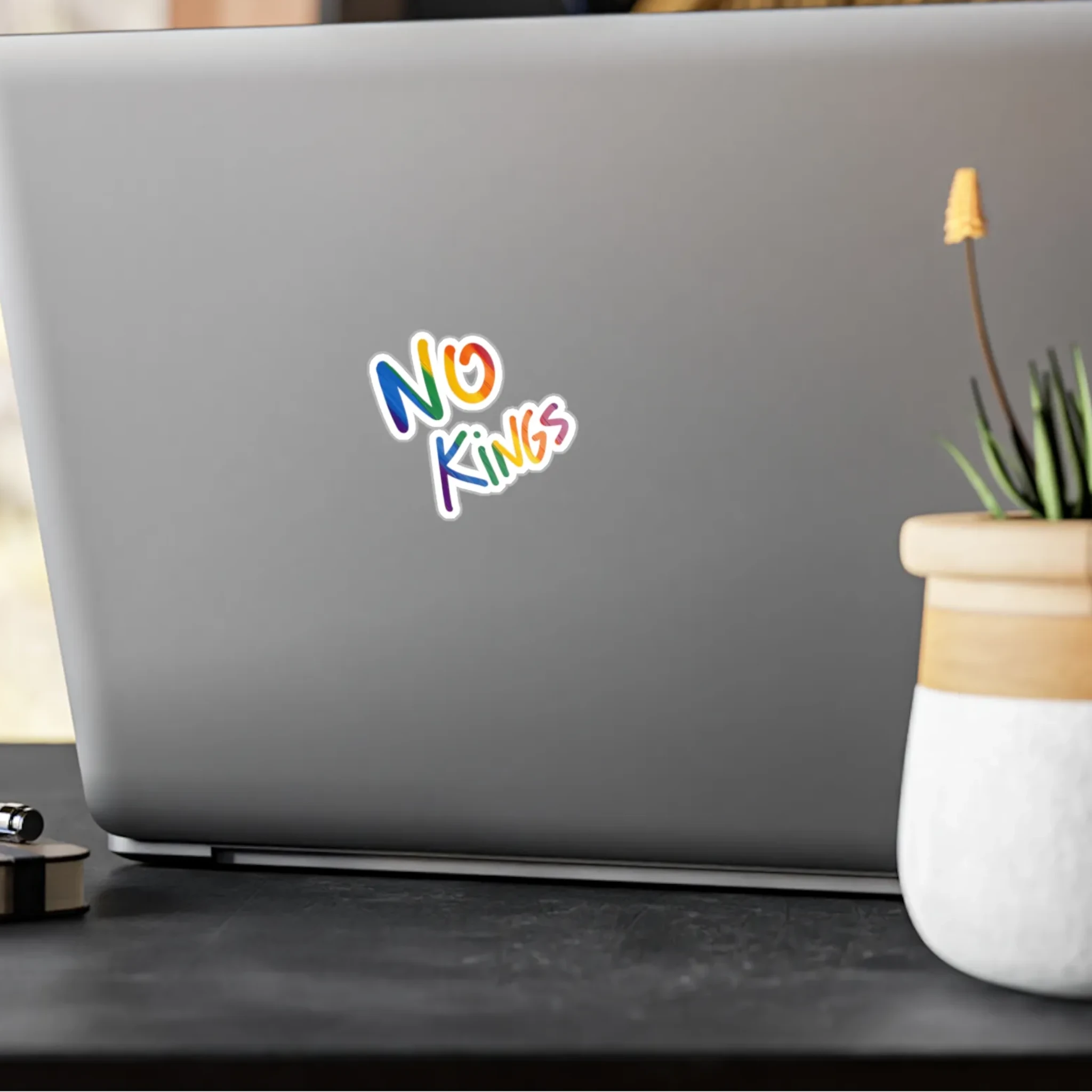No Kings rainbow kiss-cut vinyl sticker on laptop, lifestyle display, FREEBRD Pride Gear.