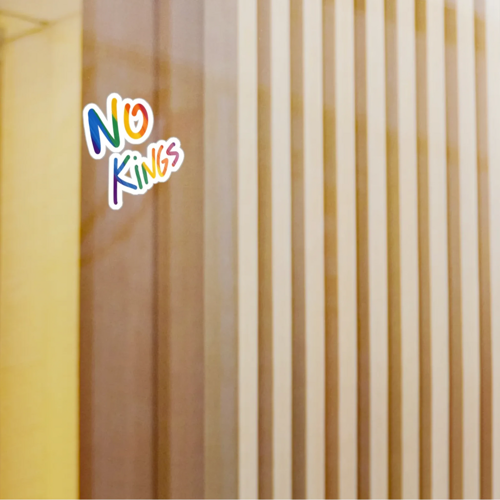 No Kings rainbow kiss-cut vinyl sticker on glass window, lifestyle display, FREEBRD Pride Gear.
