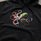 Close-up of a black pullover hoodie showing the multicolored octopus chest graphic, drawstrings and kangaroo pocket.