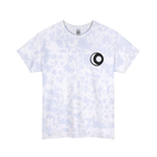 A powder cloud spiral tie-dye t-shirt with a faint purple and blue speckle pattern with white dye veins, featuring a sun and moon graphic on the front.