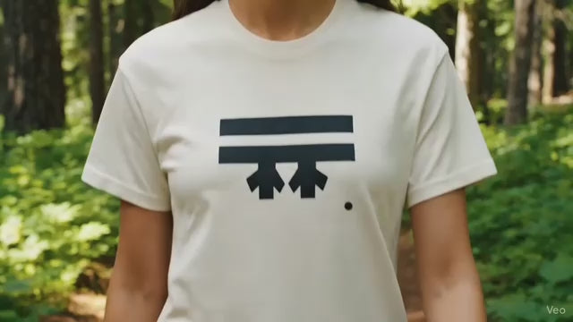 hiker on an Oregon trail wearing the FREEBRD cream Classic T-shirt that has a black FREEBRD logo graphic on the front. 