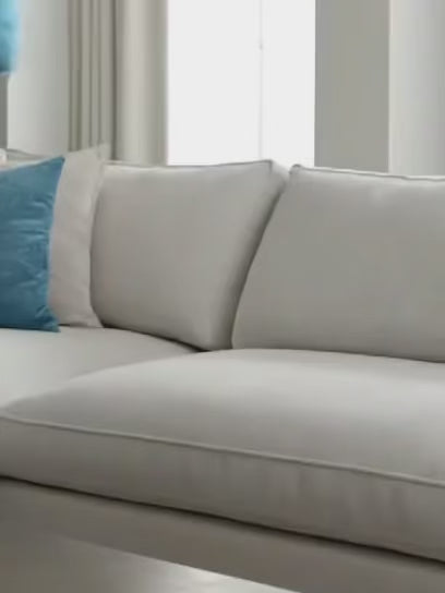 Lady placing a Vintage Aqua FREEBRD Faux suede pillow onto a beige couch.