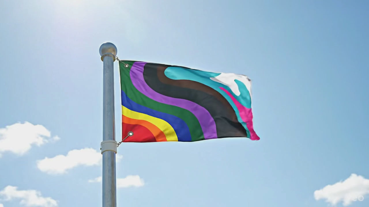 The FREEBRD designed LGBTQIA+ flag flowing in the wind on a sunny day. 
