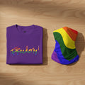 Purple t-shirt bundle with 'Freedom!' in rainbow colors and a rainbow flag on a wooden surface.