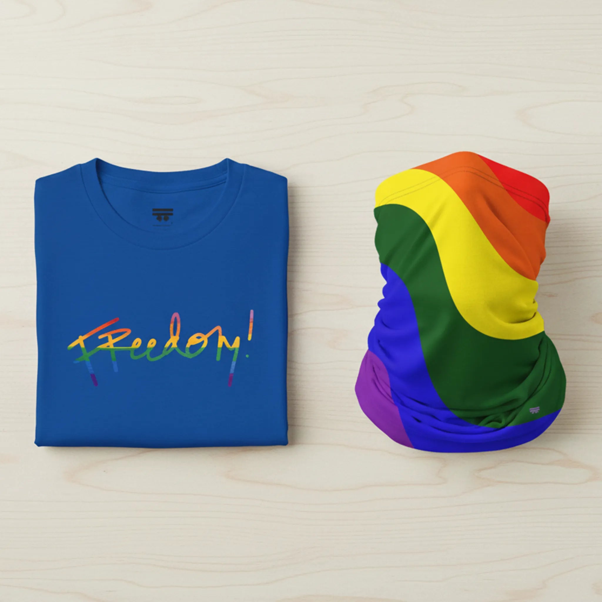 Royal Blue t-shirt bundle with 'Freedom!' in rainbow colors and a rainbow flag on a wooden surface.